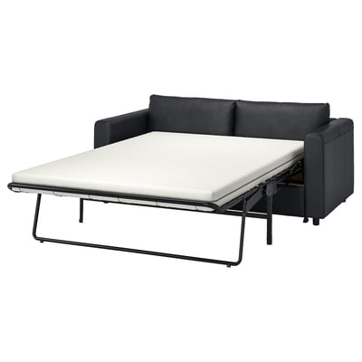 FINNALA black sofa-bed with cushions, modern design, converts into a bed with a thick mattress.