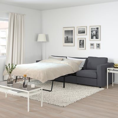 Modern bedroom FINNALA grey sofa-bed. Its compact yet spacious, with black metal legs, and matching neutral decor. Perfect for small rooms.