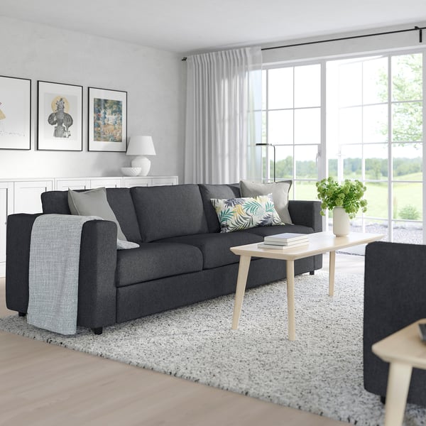 Modern living room with FINNALA sectional sofa, coffee table, and three framed pictures.