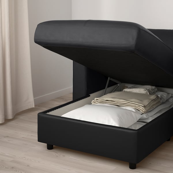 FINNALA sofa with open storage compartment, showcasing folded blankets inside.