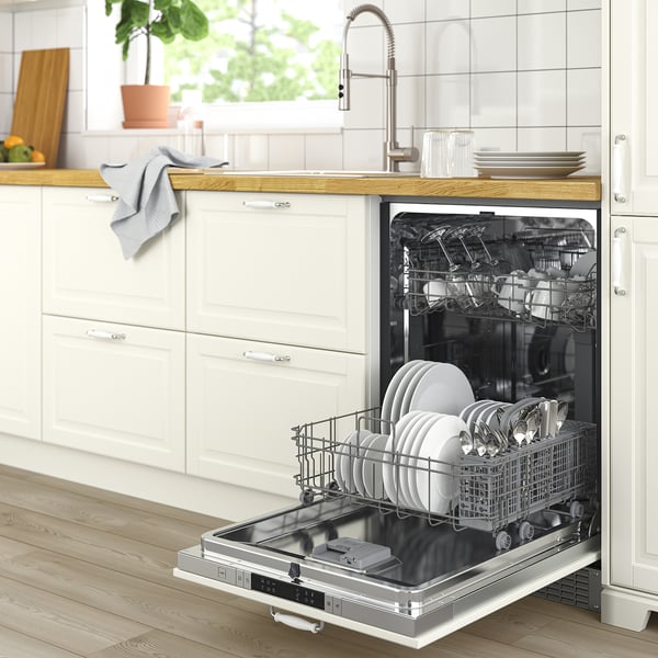 Modern kitchen with white FLÅBODA dishwasher, clean dishes, wooden counters, and greenery.