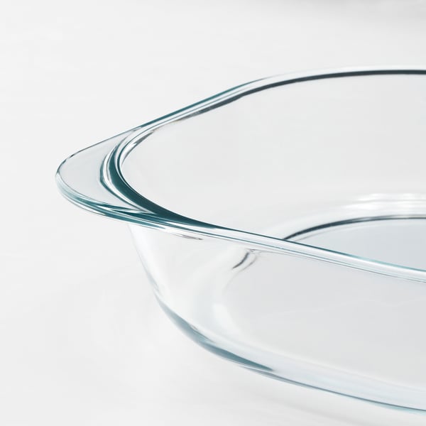 Clear glass oven dish with smooth, curved edges and slight blue tint, designed for baking and serving.