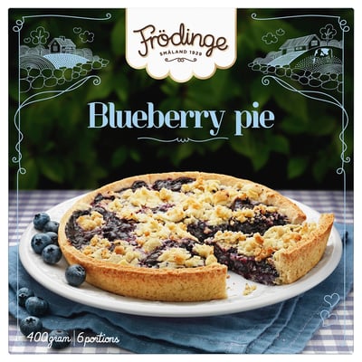 Image a blueberry pie with a missing slice. Surrounded by fresh blueberries. FRÖDINGE brand.