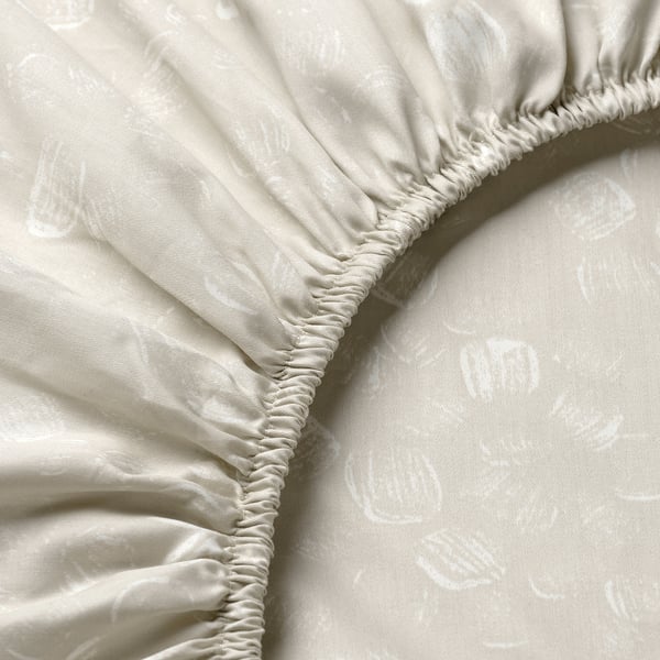 Close-up of elegant bedsheet edge, showing high-quality stitching and soft, intricate fabric pattern.