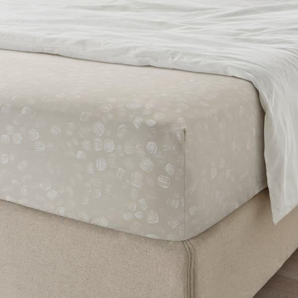 Neutral bed sheet set, fitted with elastic edges, featuring a subtle patterned design, displayed on a mattress.