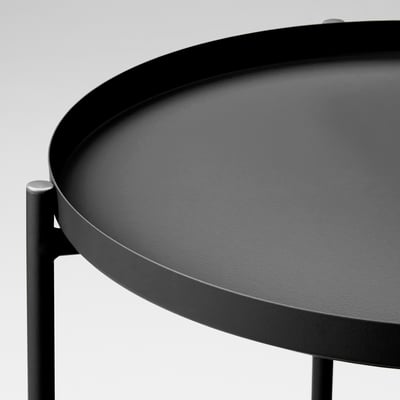 Modern round tray table with sleek black finish. Durable powder-coated steel surface, supported by sturdy metal legs.