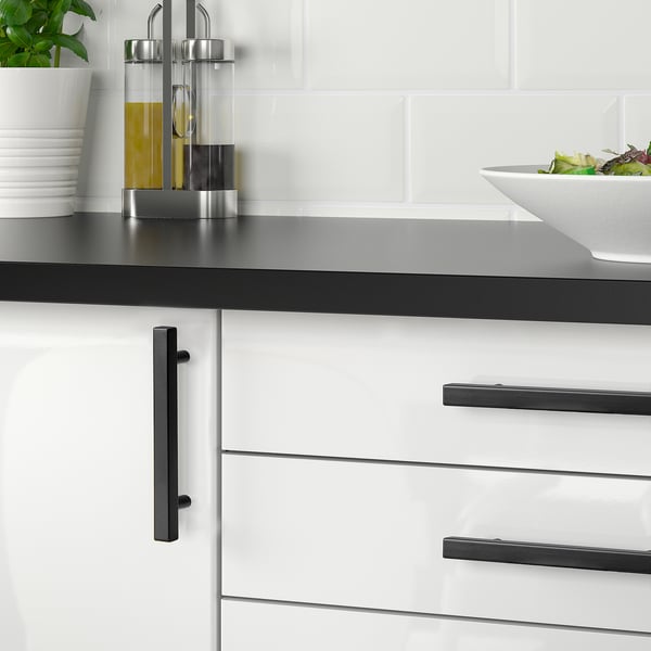Modern kitchen with GRIBBOL black handles; sleek design, easy to grip. Drawers small compared to bowl and bottles.