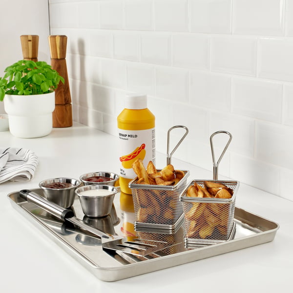 Stainless steel serving tray with baskets, bowls, and utensils for outdoor grilling.
