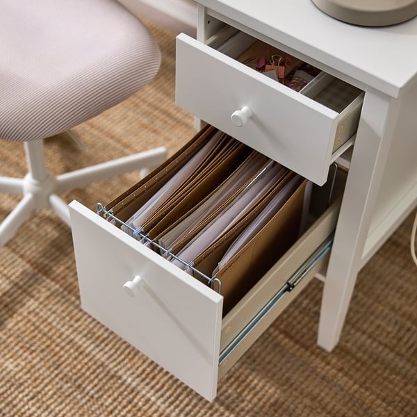 White desk drawer open, showing file folders and organised storage space.