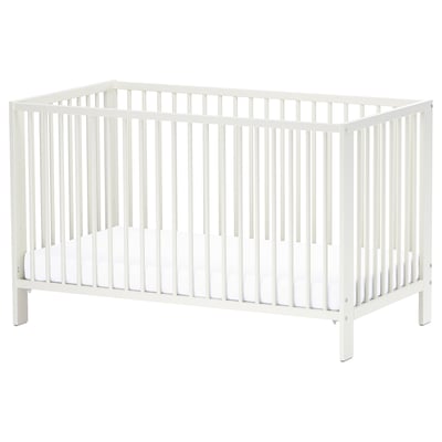 A white GULLIVER baby cot. Its a rectangular, wood-framed crib with vertical slats on all sides. The design is simple and functional.