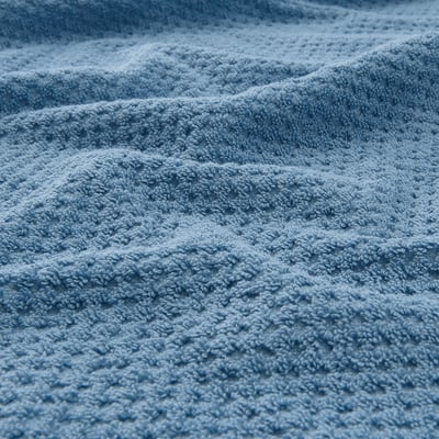 Close-up of soft, beige, textured cotton towel; feels thick, absorbent, and durable.