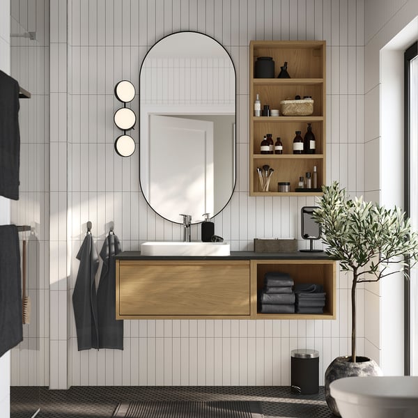 Modern bathroom with hagån vanity, mirror, cabinet, and plant.