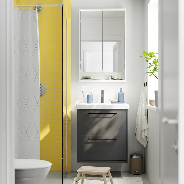 Small modern bathroom featuring HAVBÄCK dark grey vanity with white countertop, mirror cabinet, and yellow tiled shower.