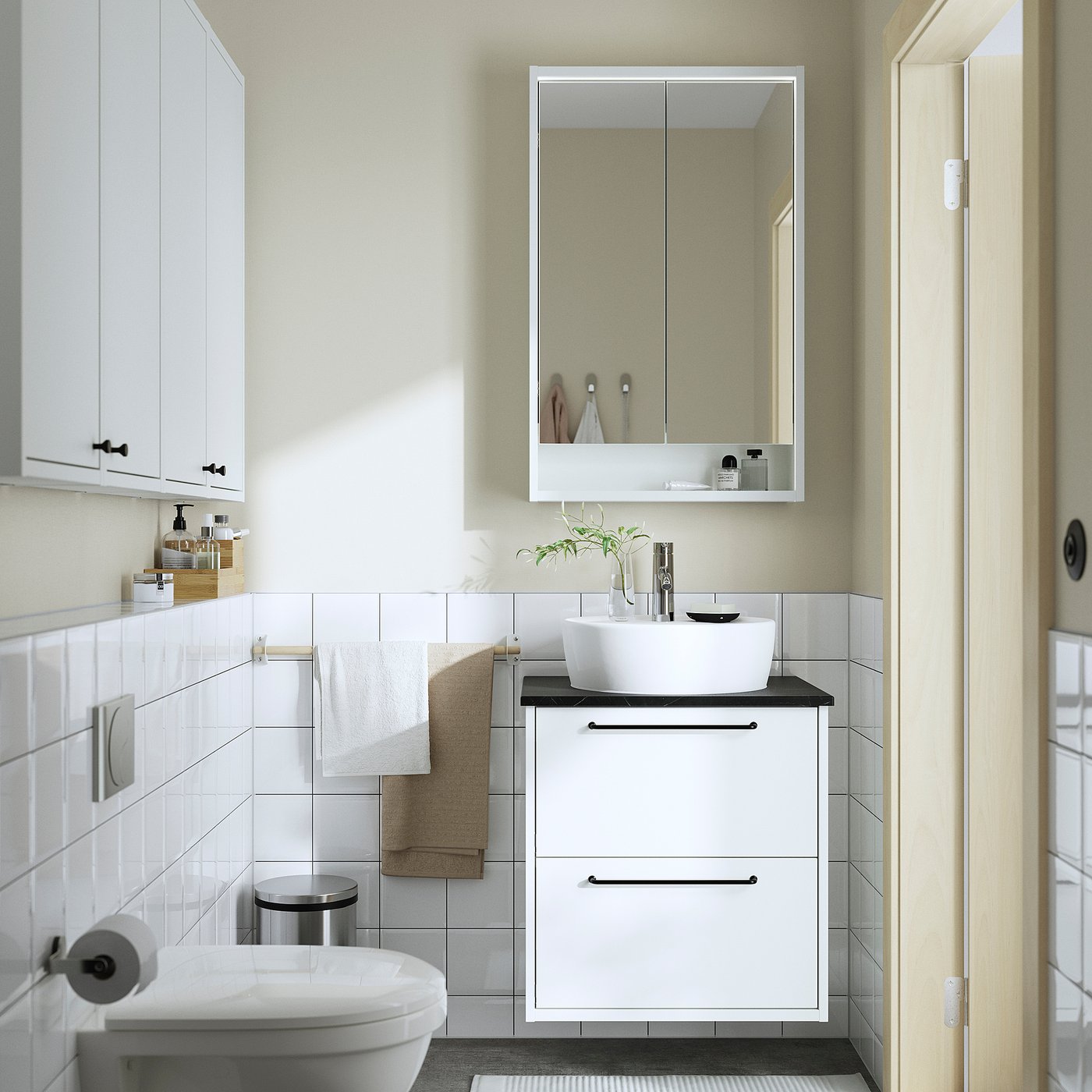 Modern white bathroom with HAVBÄCK vanity, round basin, mirror, towels, and toilet. Clean, sleek design with wall-mounted cabinet.