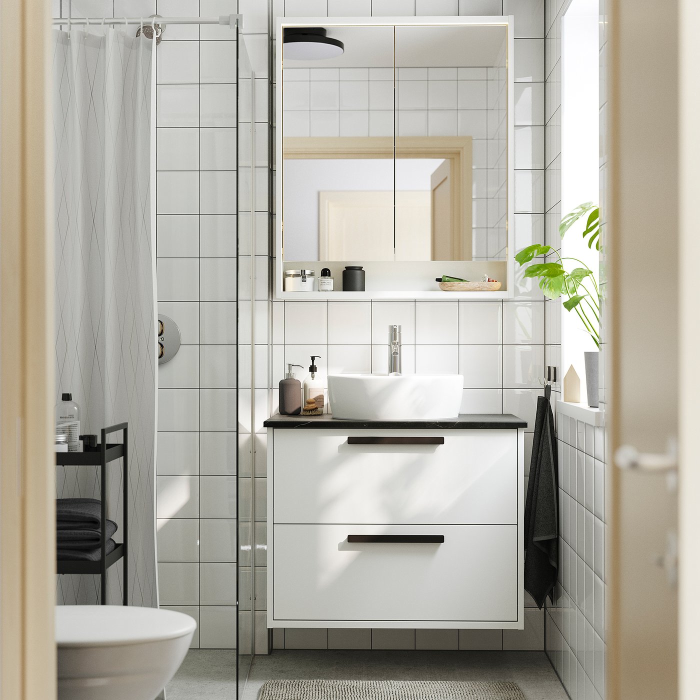 Modern bathroom with HAVBÄCK cabinet. Wall-mounted, minimalist design. Mirror, glass shower, sink with chrome tap. White tiled walls, grey towel.