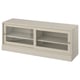 A beige HAVSTA tv cabinet with sliding glass doors, made of solid pine wood, featuring a rustic design.
