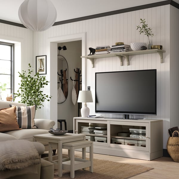 Modern living room with white HAVSTA tv stand, beige sofa, wooden floor, and plants.