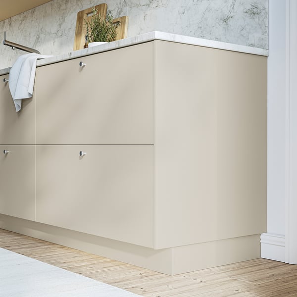 Beige HAVSTORP cabinet with 2 drawer handles, decor tray with plants.