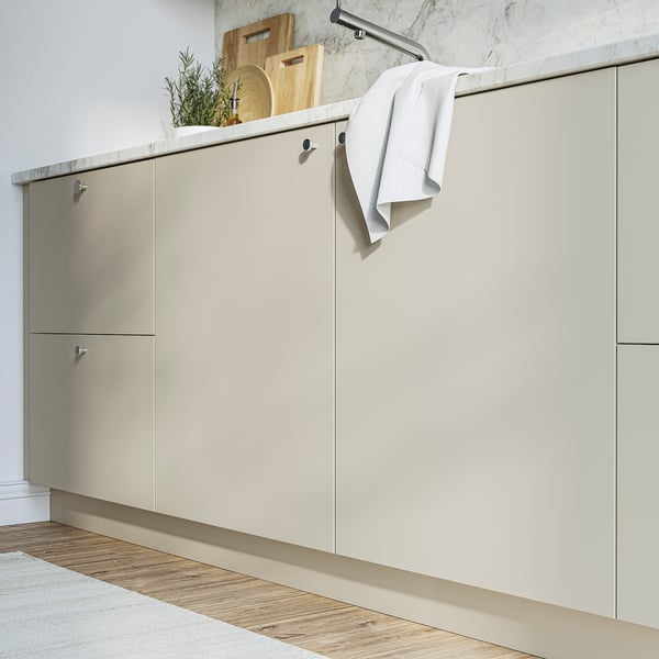 Beige HAVSTORP cabinets with clean lines. Made of acrylic paint and fibreboard. White towel nearby.