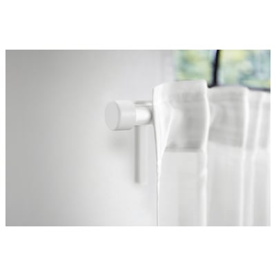 White, spherical HELTUSS finials made of recycled plastic. They have a sleek, minimalist design, suitable for curtain rods.