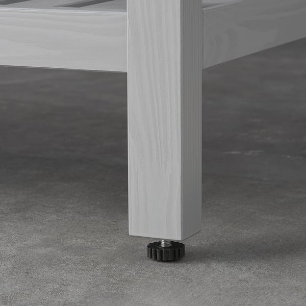 Close-up of HEMNES furniture leg, smooth finish, and adjustable foot.