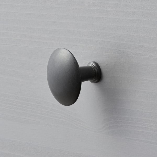 A sleek, matte black wall hook securely mounted on a smooth, light grey wall. Modern and minimalist design.