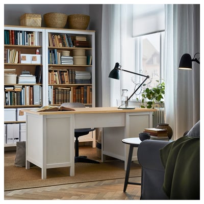 Modern home office with white HEMNES desk, grey chair, black lamp, bookshelves, and green accents.