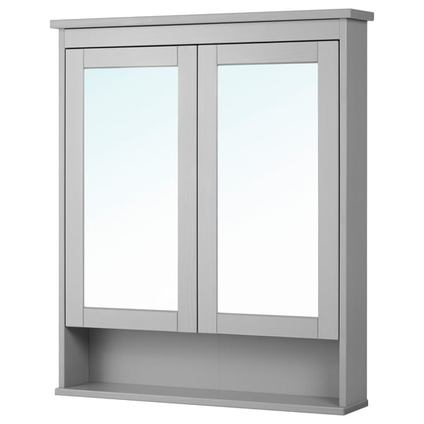 The HEMNES mirror cabinet in grey double doors with tempered glass and a fixed shelf below, ideal for bathroom storage.