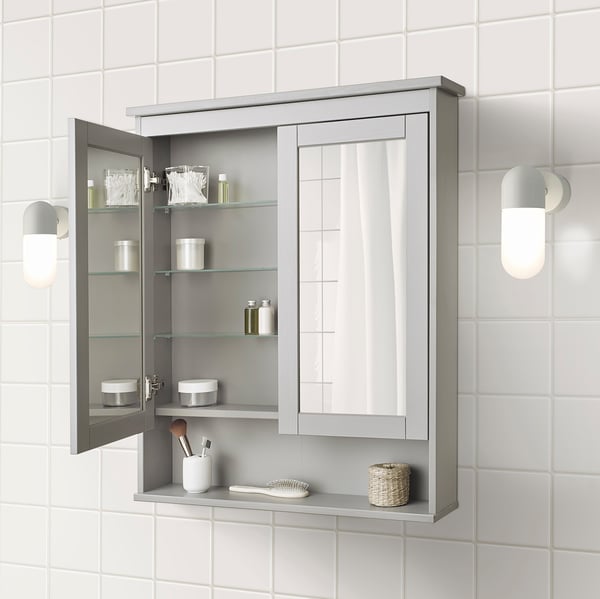 Wall-mounted HEMNES mirror cabinet with adjustable shelves storing toiletries.