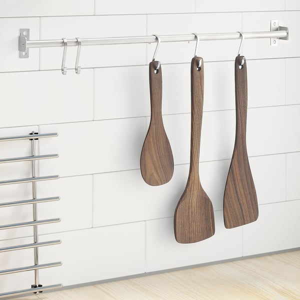 Three wooden spatulas hang on hooks, dark brown, natural grain, medium size.