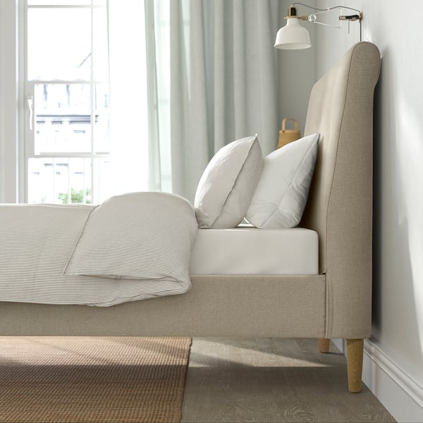 Bed frame with upholstered headboard, wooden legs, and adjustable bed sides for varied mattress thickness.