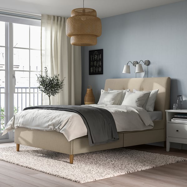 Modern bedroom with IDANÄS bed, drawers, lamp, window curtains, and vase. Cosy atmosphere.