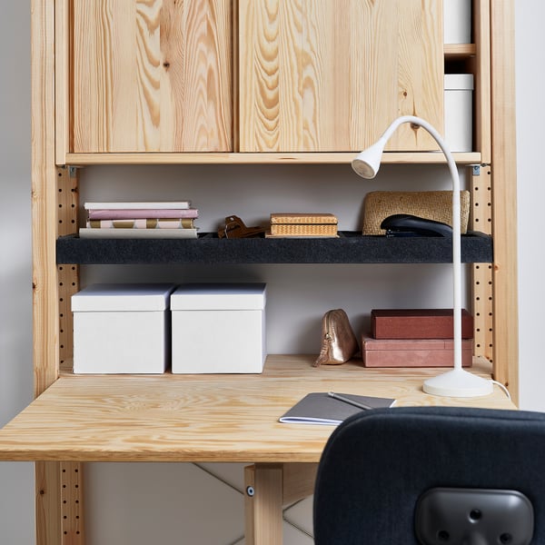 Wooden desk with shelves, books, boxes, and a lamp.