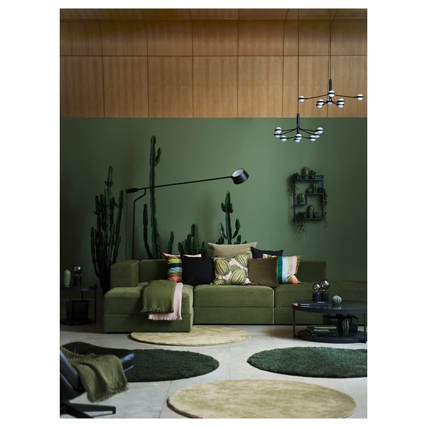 Olive green JÄTTEBO sofa in modern living room with wall decor and rugs.
