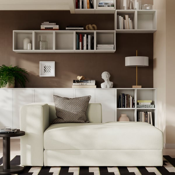 Modern living room with JÄTTEBO sofa, rug, lamp, and decorated shelves.