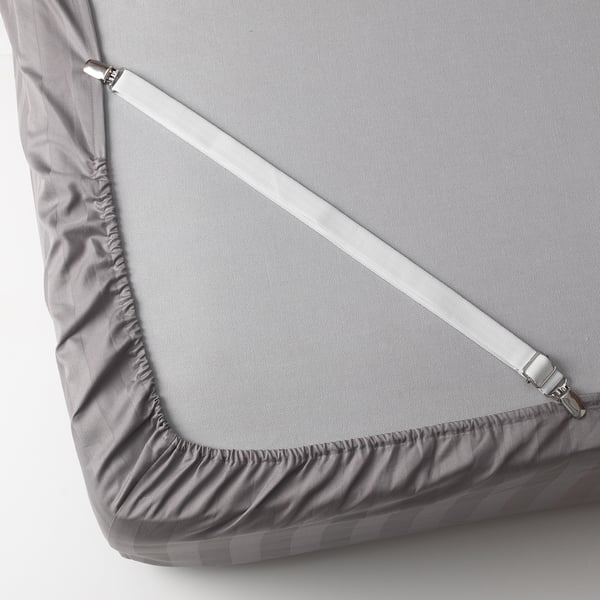 Grey fitted sheet straps snapped under mattress corners.