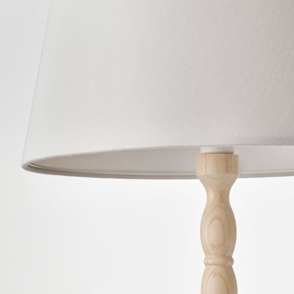 Elegant lamp with smooth, turned wooden base and beige shade, showcasing quality craftsmanship.