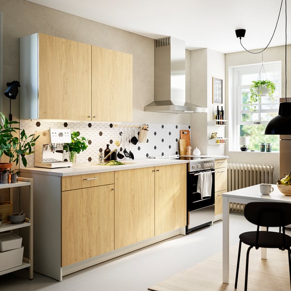 Modern kitchen with KNOXHULT wood cabinets, marble counter, black dot backsplash, stainless appliances, efficient storage.