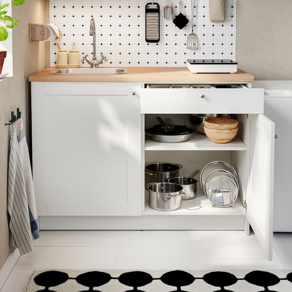Kitchen cabinet with pots, pans, and utensils; includes sink, counter, and shelf storage.