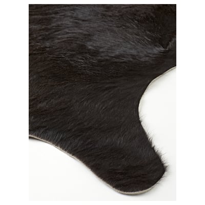 Black cowhide rug with natural texture and slight variations in colour, displayed against a white background.