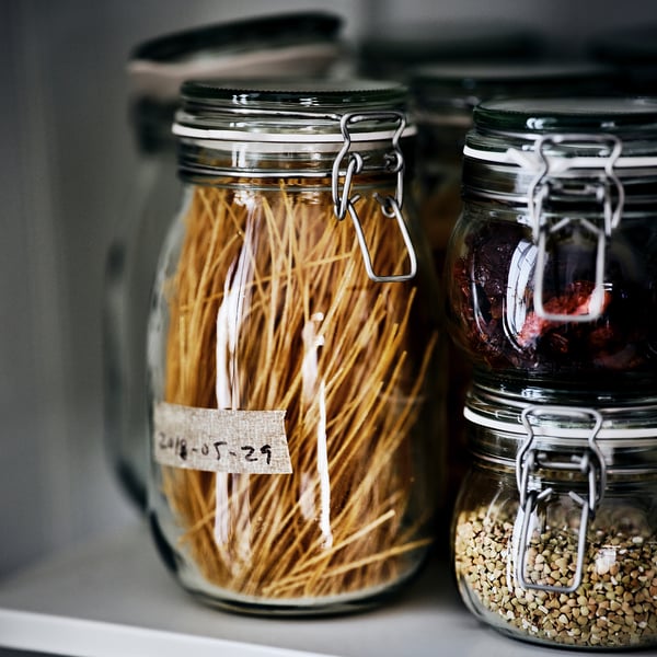 Glass jars labelled and filled with dry goods and preserved foods, sealed for freshness.