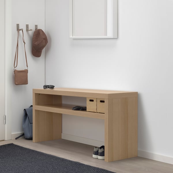 Minimalist LACK console in light oak, white wall, honeycomb paper, shoe storage, blue backpack, brown hat, purse.