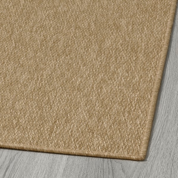 Close-up of beige woven rug, quality materials, soft texture, suitable for indoors or outdoors.