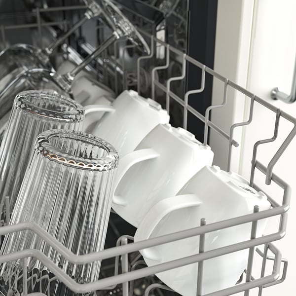 Dishwasher racks filled with glassware and plastic containers, showing adjustable basket heights.