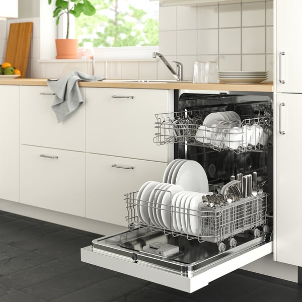 Open dishwasher in modern kitchen. Its white, large, fits below counter, holds clean dishes and cutlery neatly. Door stays open to dry.