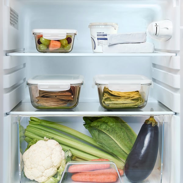Refrigerator shelf with adjustable compartments holding veggies and containers.