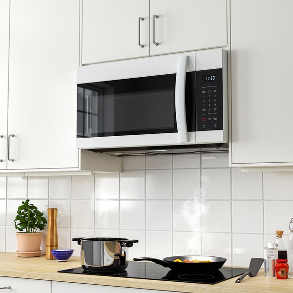 Modern kitchen with white LAGAN microwave under cabinet, stainless steel handle, blending well with white cabinetry.