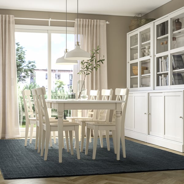 Bright dining room with LANDBANA blue jute rug, white table & chairs, cabinet, and large window.
