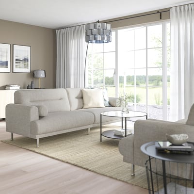 Modern living room with LÅNGARYD sofa, coffee table, armchair, large window, sheer curtains, natural light.