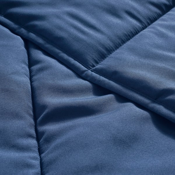 Close-up of soft, navy-blue comforter, showcasing luxurious, smooth texture and meticulous stitching.